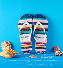pair of multi-colored rubber slippers on a blue background