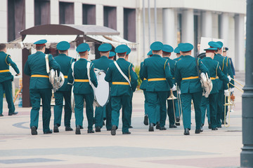 A wind instrument parade - people in green costumes walking on the street