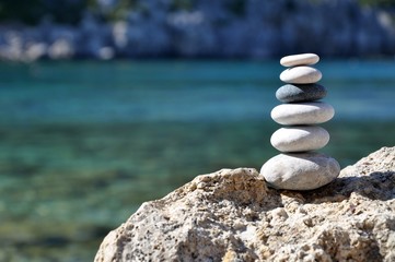 Fototapeta na wymiar Stones balance on beach. Day and sun. 