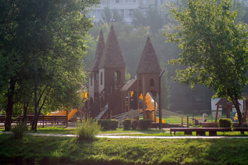 empty children's playground in the form of a castle on a summer morning in the park