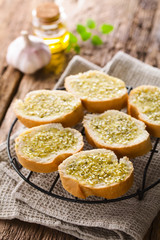 Fresh homemade garlic bread, slices of baguette seasoned with garlic, oregano, salt, pepper and olive oil (Selective Focus, Focus one third into the image)