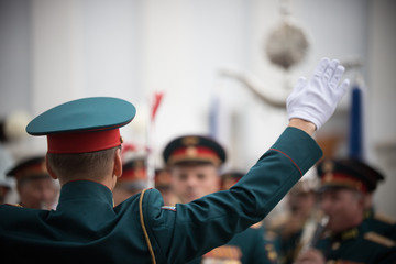 A wind instrument parade - people in green costumes follows the conductor