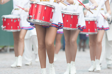 A wind instrument parade - women in small skirts playing drums