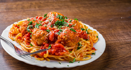 pasta spaghetti with meatballs in tomato sauce on a plate on wooden table background