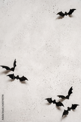 halloween decoration concept - black bats on white concrete background