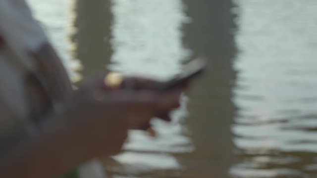 Woman using Cell Phone by River Slow Motion 4K