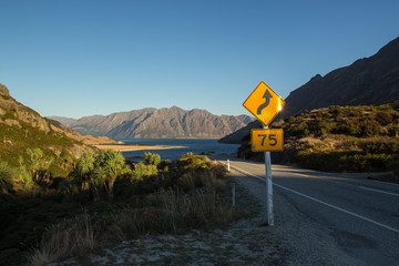 landscape view of road in front of beautiful lake hawea in new zealand south island