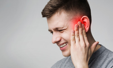 Suffering man touching his inflamed head, empty space