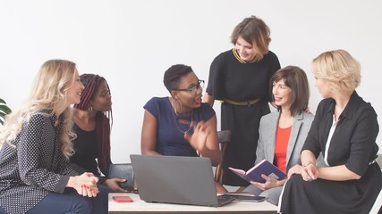 Office workers listen attentively to marketing Director in office.
