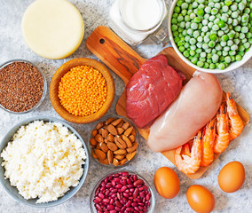 Assortment of Products with high level of protein. Healthy Protein Source. Foods for muscles building. Meat, seafood, cheese, milk, nuts, legumes, seeds, eggs, vegetables. Light background. Top view