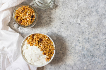 Bowl of Homemade granola with Greek yogurt on a light background. Ingredients for a healthy breakfast. Top view