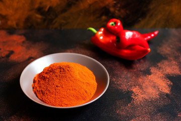 Paprika powder in a plate on a colorful oriental background. Bright colours. Selective focus. Space for text. Close-up