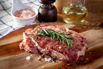 Fresh steak on a wooden cutting board with ingredients