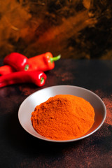 Paprika powder in a plate on a colorful oriental background. Bright colours. Selective focus. Vertical. Space for text. Close-up