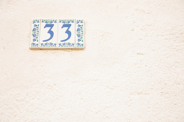 Number 33 street address tile on old wall.