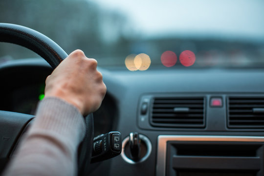 Driver's hands driving a car on a highway (color toned image; shallow DOF)