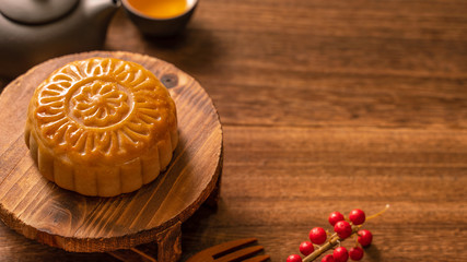 Chinese traditional pastry Moon cake Mooncake with tea cups on bamboo serving tray on wooden background for Mid-Autumn Festival, close up.