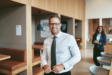 Smiling mature businessman standing in a modern office