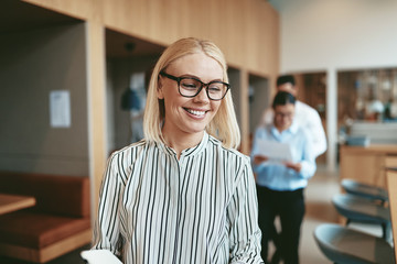 Smiling young businesswoman walking through a modern office