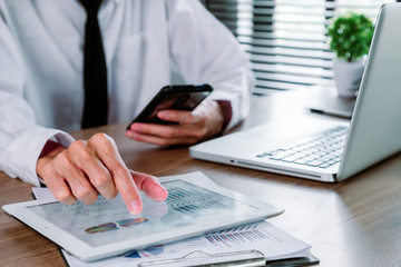 Fototapeta premium Businessman analysis financial data on digital tablet and smart phone and laptop computer.Business analysis and strategy concept.