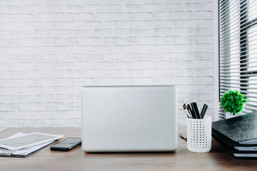 Financial office desk with laptop computer, smart phone and office supplies.