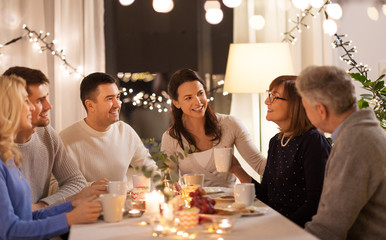 celebration, holidays and people concept - happy family having tea party at home