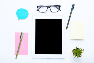 Tablet computer with office supplies on white background