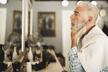 Senior client estimating work of barber in mirror