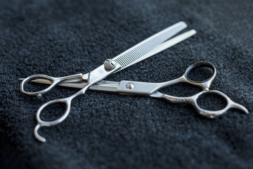 Hairdressers scissors lying on dark cloth