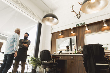 Senior client and hairdresser discussing about work
