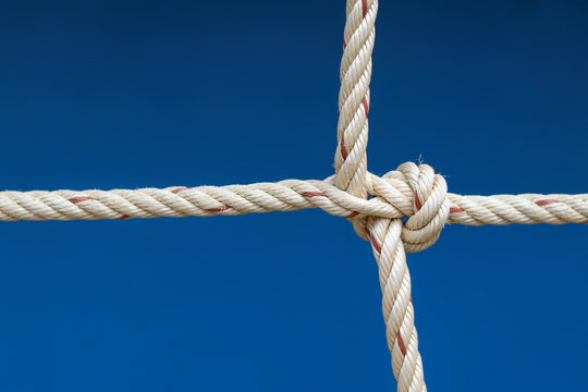Nylon rope tied into a knot with blue background.
