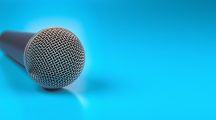Macro shot of microphone on blue glossy table with dof effect.