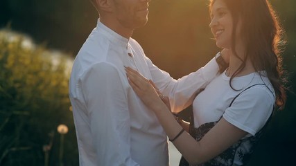 Couple in a park by the river in summer at sunset. Love, relationship, kiss