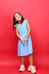 Beautiful little girl in blue dress on red background