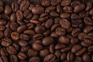 Naklejka premium Coffee beans on stone background. Top view with copy space for your text. Roasted coffee beans background. Beans texture, macro