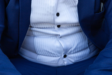 close up a fat man in a suit.symbolic photo for beer belly, unsuccessful dieting and eating the...