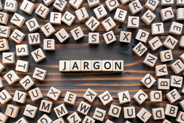 Jargon  - word from wooden blocks with letters,  special words and phrases jargon concept, random letters around, top view on wooden background