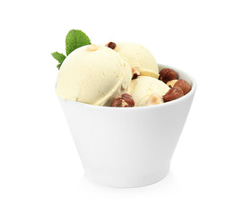 Delicious vanilla ice cream with hazelnuts and mint in dessert bowl on white background