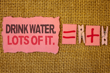 Handwriting text writing Drink Water. Lots Of It. Concept meaning drinking liquids to keep our body in great status Jute sacks plus two paper clip equal pink paper with black and red letter