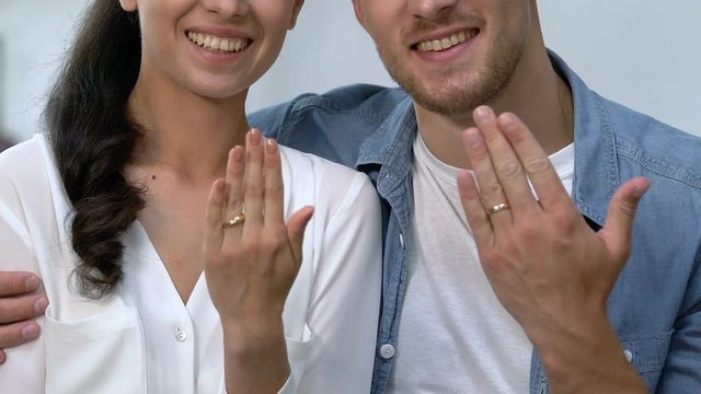 Happy loving couple showing engagement rings on fingers, future family, joy