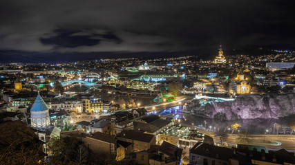 Fototapeta premium Night view of Tbilisi with Sameba (Trinity) Church and other landmarks. Travel.