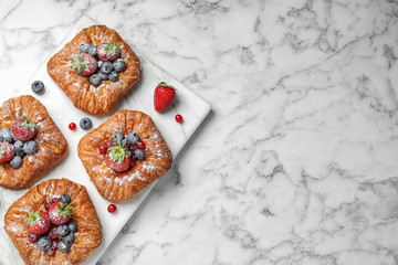 Fresh delicious puff pastry with sweet berries on white marble table, top view. Space for text © New Africa