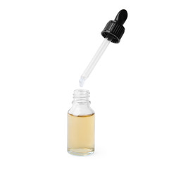 Dripping essential oil from pipette into glass bottle on white background