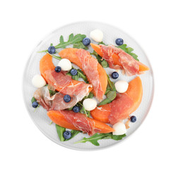 Fresh melon with prosciutto, mozzarella and arugula on white background, top view