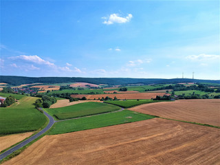 Farmland with fields and country road. Sky and clouds. Photographed from above