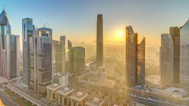 Sunrise over Dubai skyline in the morning, aerial top view to downtown city center landmarks timelapse. Famous viewpoint, foggy weather. United Arab Emirates