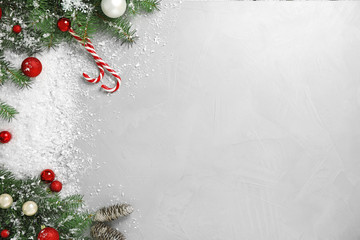 Christmas decoration with white snow on light grey stone background, flat lay. Space for text