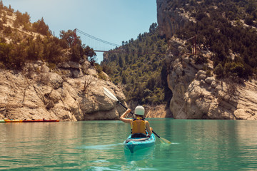 Woman in kayak on a river crossing a gorge in the Pyrenees mountains