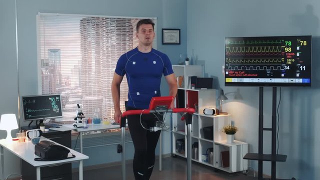 Strong athlete doing cardiac stress test on racetrack in sport lab with modern equipment. In Scientific Sports Laboratory.
