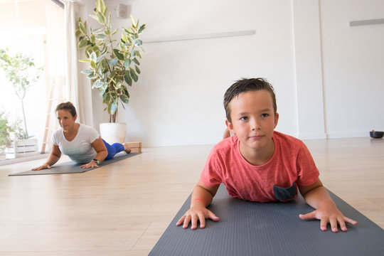 Ni&ntilde;os j&oacute;venes realizando yoga con esterilla en interior